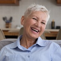 Older woman smiling, glad she could afford dentures