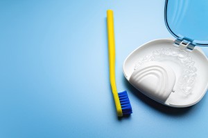 Invisalign aligner next to toothbrush