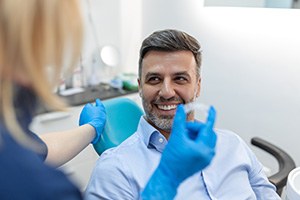 Male Invisalign patient looking at dental team member