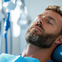 Relaxed man reclined in dental treatment chair