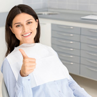 Happy dental patient making thumbs up gesture